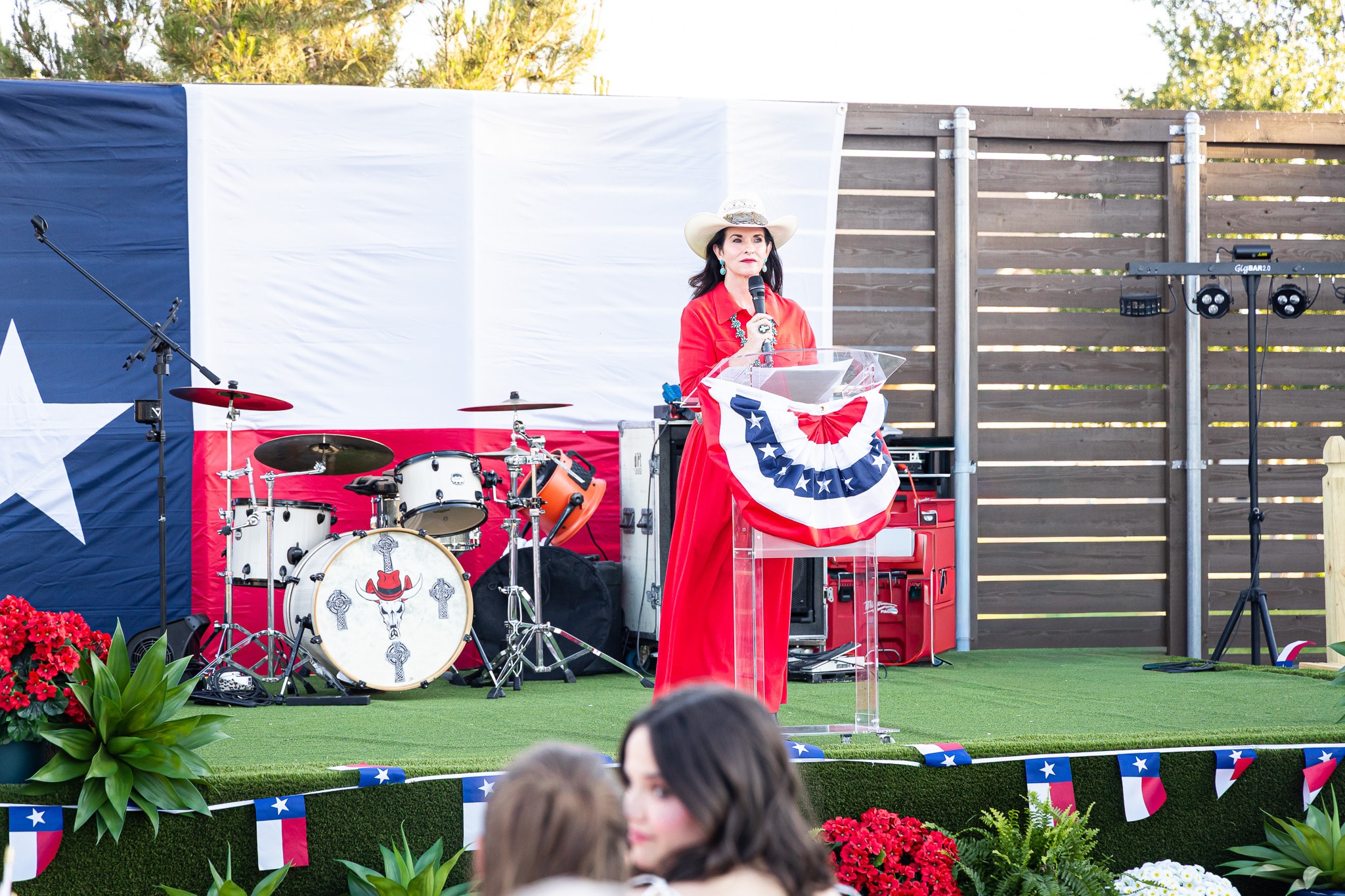 Ashley speaking at an outdoor patriotic stage event